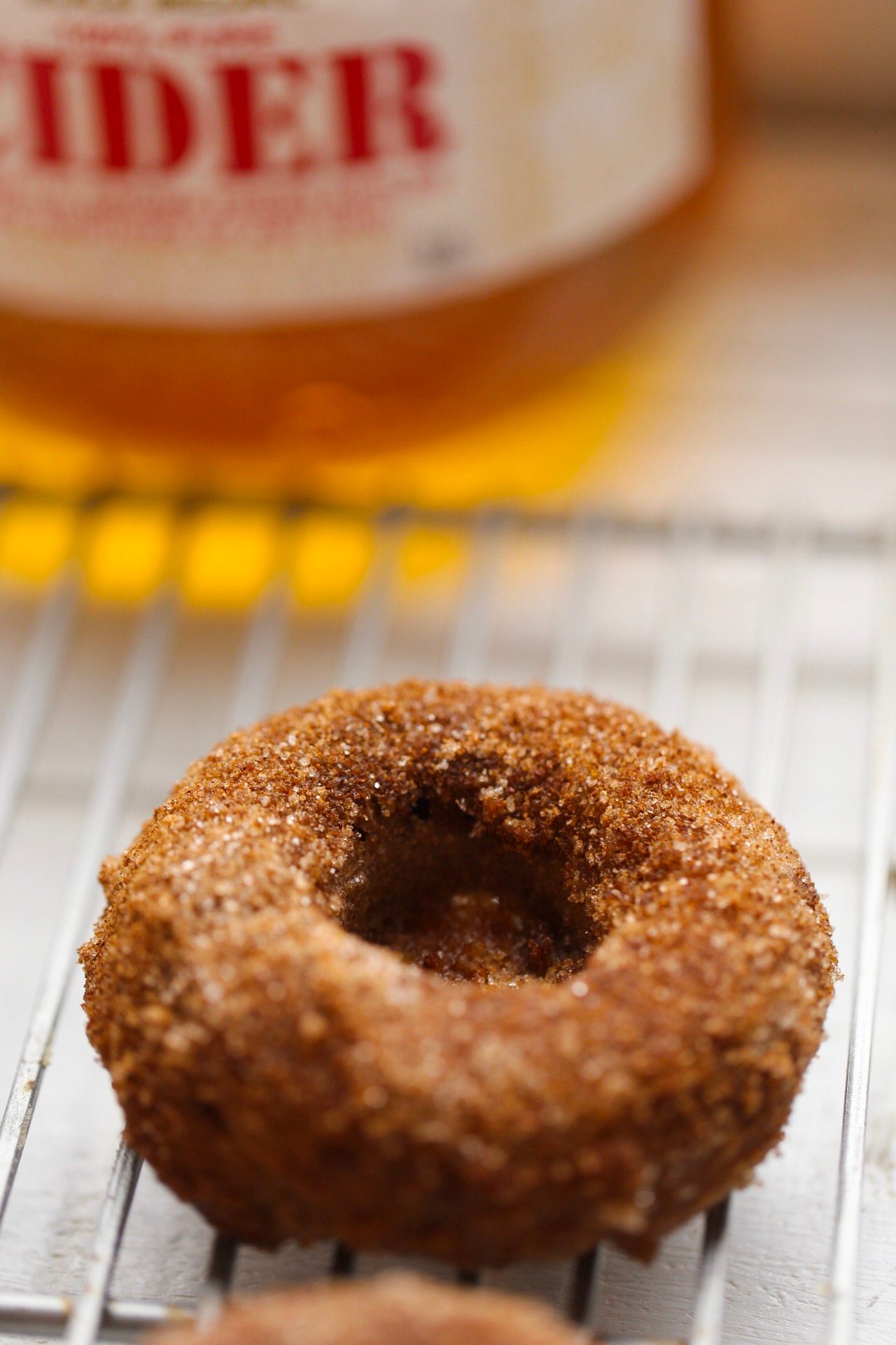 A cinnamon-sugar vegan donut on a cooling rack